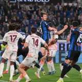 Piłkarze AS Roma i Atalanty walczą o piłkę w powietrzu. W akcji zawodnicy z numerami 17, 14 i 16.