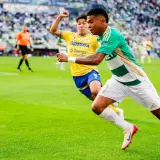 Piłkarz Lechii Gdańsk w akcji przeciwko Arce Gdynia. Piłka w grze na zielonej murawie stadionu.