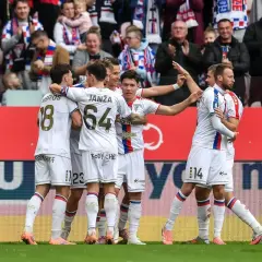 Piłkarze Górnika Zabrze w białych strojach świętują bramkę, w tle kibice.
