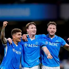Piłkarze Napoli świętują zwycięstwo nad Hellas Verona. Radość na twarzach zawodników, jeden z nich unosi pięść w geście triumfu.