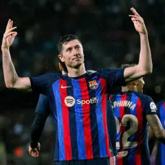 Robert Lewandowski, król strzelców, w koszulce Barcelony z podniesionymi rękami, świętuje zwycięstwo.