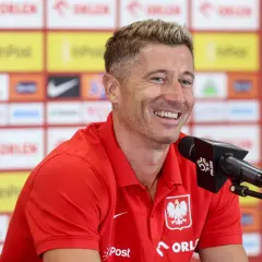 Uśmiechnięty Robert Lewandowski w czerwonej koszulce z orłem. Ciekawe, ile języków zna Robert Lewandowski, by dogadać się z fanami z całego świata.