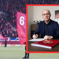 Nowy trener Widzewa podpisuje kontrakt. W tle kibice na stadionie z flagami.