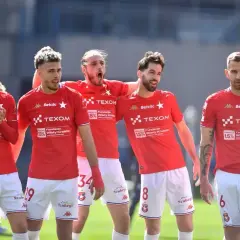 Piłkarze Wisły Kraków w czerwonych strojach świętują. Nowe transfery wzmocnią drużynę w walce o mistrzostwo.