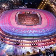 Nowy Camp Nou nocą, oświetlony różowo-niebieskimi światłami, z widocznymi trybunami i napisem "NOU CAMP NOU".