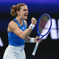 Maria Sakkari triumfuje, zaciskając pięść i krzycząc z radości na korcie tenisowym.