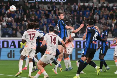 Piłkarze AS Roma i Atalanty walczą o piłkę w powietrzu. W akcji zawodnicy z numerami 17, 14 i 16.