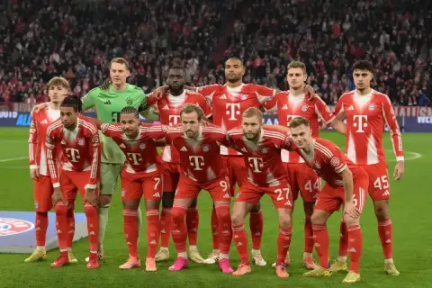 Drużyna Bayernu Monachium, znana z występów w **Bundeslidze**, prezentuje się w czerwono-białych strojach. Zawodnicy stoją gotowi do gry.
