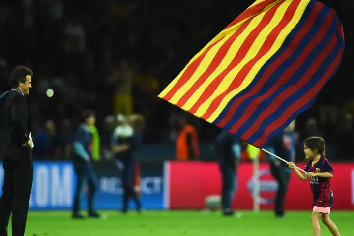 Luis Enrique córka, mała dziewczynka w stroju FC Barcelony, dumnie niesie flagę klubu.