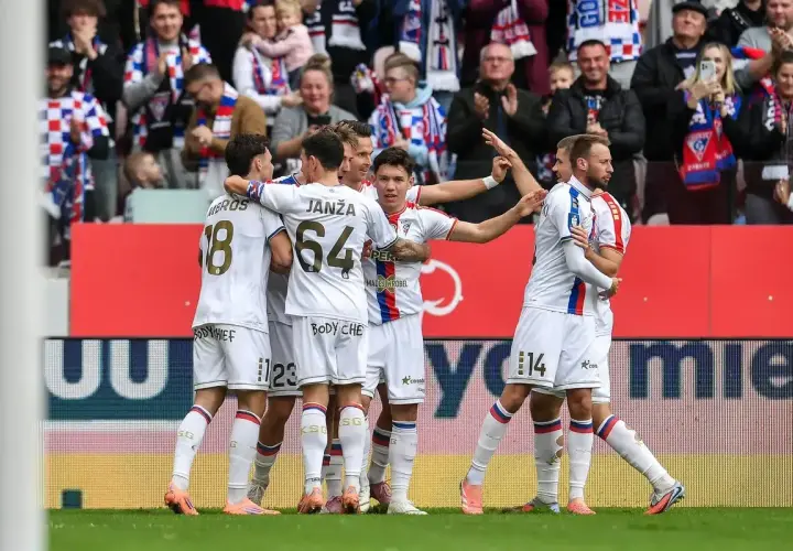 Piłkarze Górnika Zabrze w białych strojach świętują bramkę, w tle kibice.