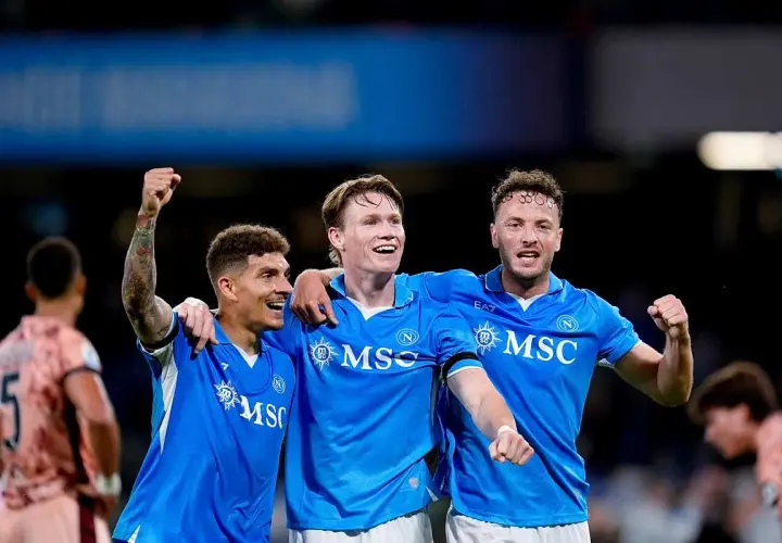 Piłkarze Napoli świętują zwycięstwo nad Hellas Verona. Radość na twarzach zawodników, jeden z nich unosi pięść w geście triumfu.