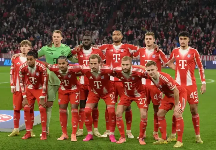 Drużyna Bayernu Monachium, znana z występów w **Bundeslidze**, prezentuje się w czerwono-białych strojach. Zawodnicy stoją gotowi do gry.