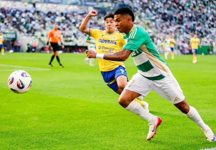 Piłkarz Lechii Gdańsk w akcji przeciwko Arce Gdynia. Piłka w grze na zielonej murawie stadionu.