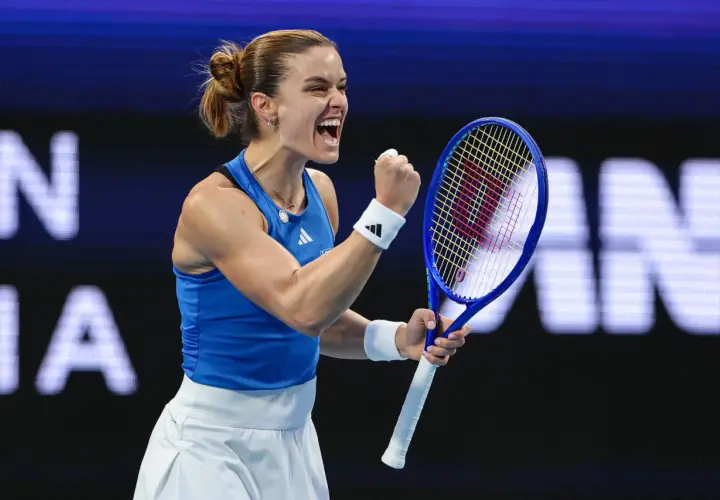Maria Sakkari triumfuje, zaciskając pięść i krzycząc z radości na korcie tenisowym.