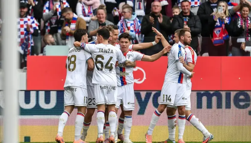 Piłkarze Górnika Zabrze w białych strojach świętują bramkę, w tle kibice.