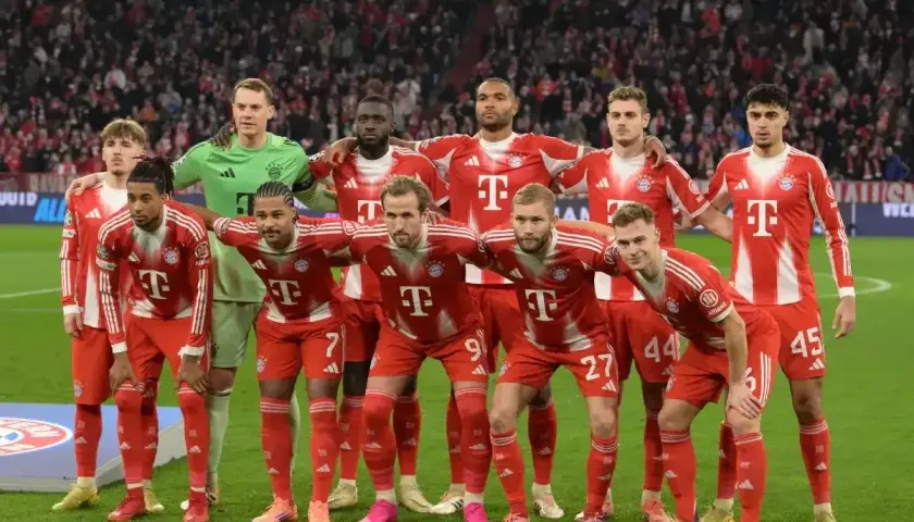 Drużyna Bayernu Monachium, znana z występów w **Bundeslidze**, prezentuje się w czerwono-białych strojach. Zawodnicy stoją gotowi do gry.