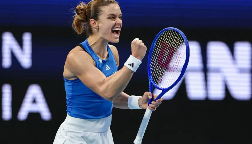 Maria Sakkari triumfuje, zaciskając pięść i krzycząc z radości na korcie tenisowym.
