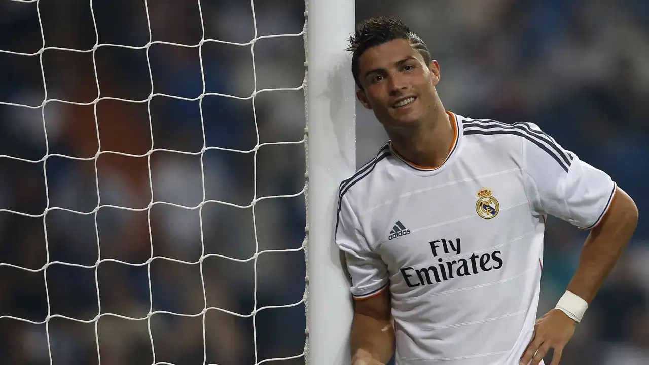 Cristiano Ronaldo oparty o słupek bramki, uśmiecha się. Jego Ronaldo Wzrost i Waga to klucz do sukcesu na boisku.