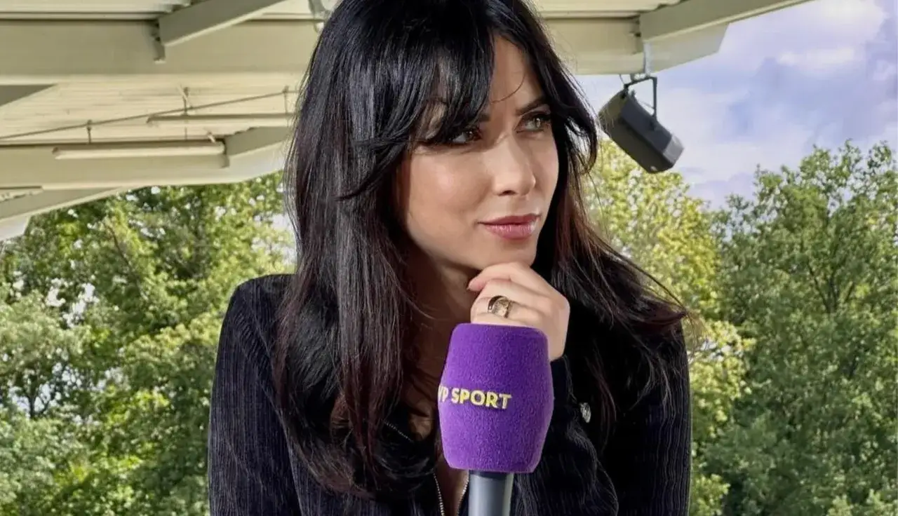 Maja Strzelczyk z mikrofonem Polsat Sport, w czarnej kurtce, na tle zieleni i nieba.