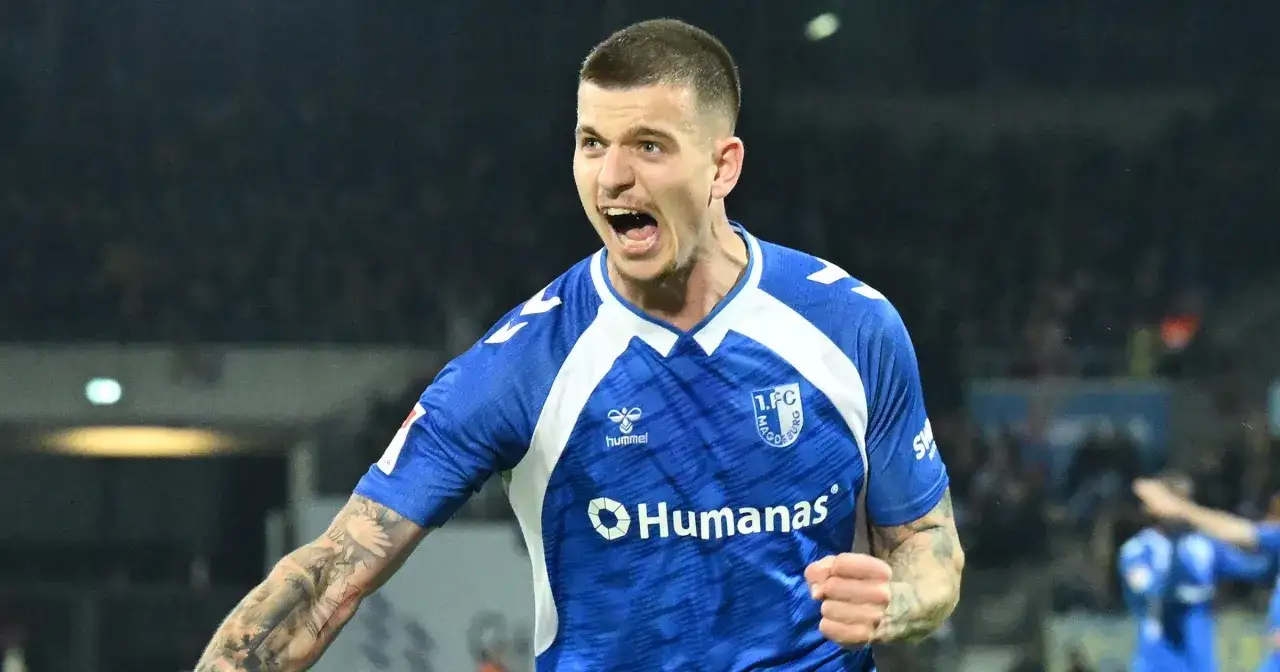 Piłkarz 1. FC Magdeburg w akcji podczas meczu Bundesliga. Zawodnicy świętują bramkę, emocje na twarzy.