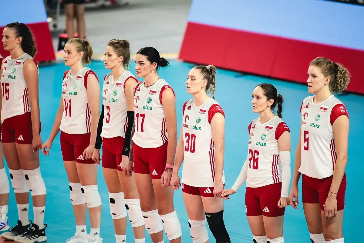 Polskie siatkarki w białych strojach z czerwonymi elementami stoją w rzędzie, gotowe do gry.